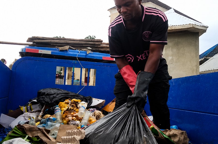 Israel Sanitation Solutions crew member sorting household waste in the truck bed